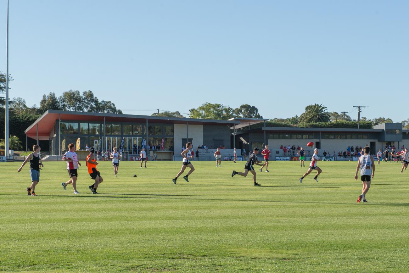 Long shot of a football oval with several players playing a game of AFL