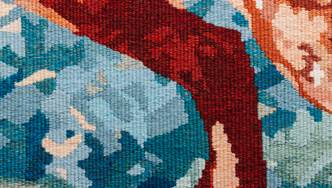 Close-up shot of the stitches in a colourful tapestry, detailing the leg and tail of a fox