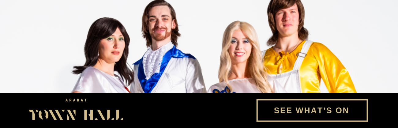 Four people standing side by side wearing ABBA costumes