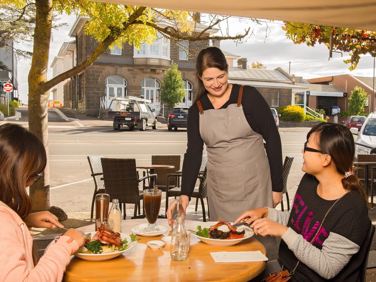 Three people smiling sitting in a cafe