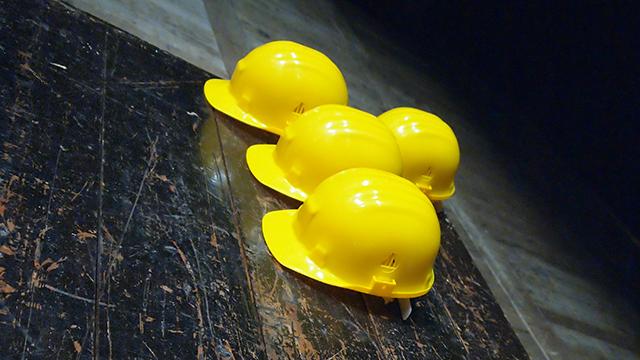 Yellow construction hardhats on a wooden floor